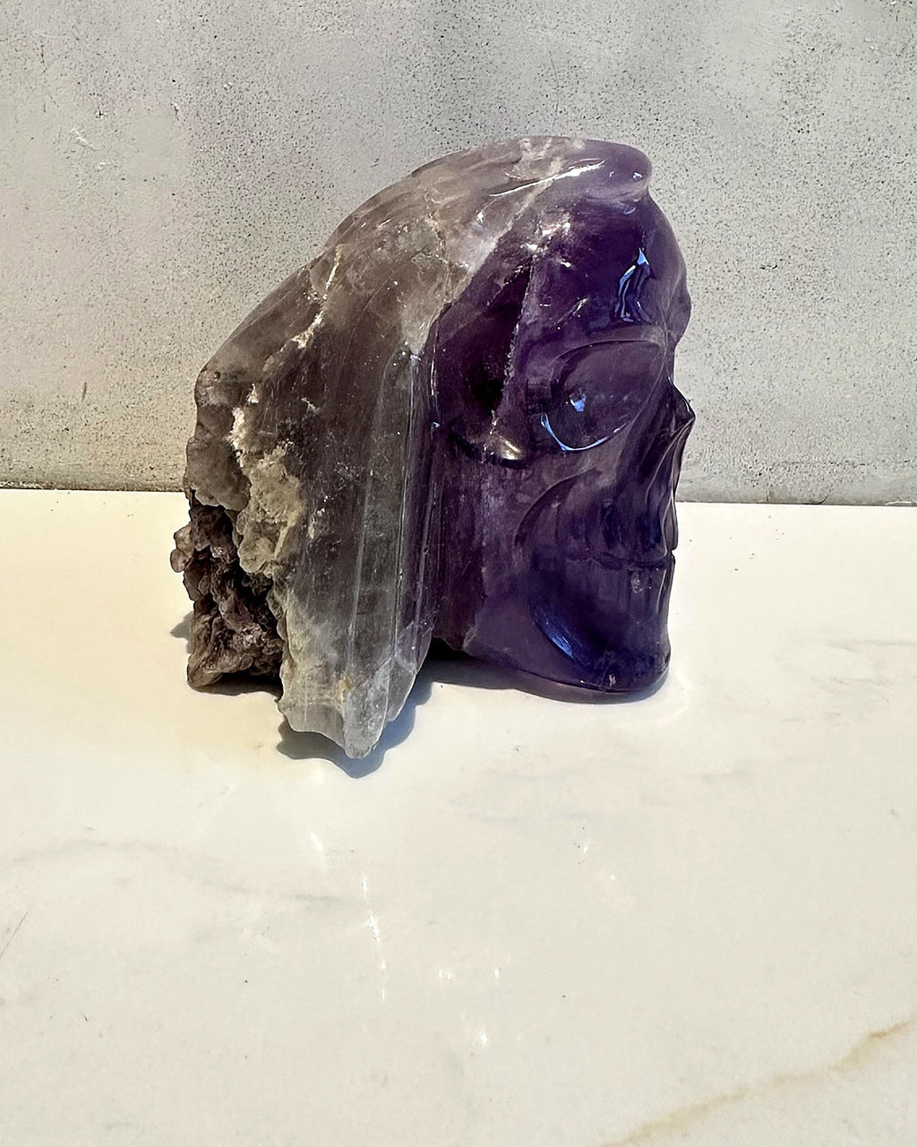 Side view of the amethyst skull showing its natural raw crystal back