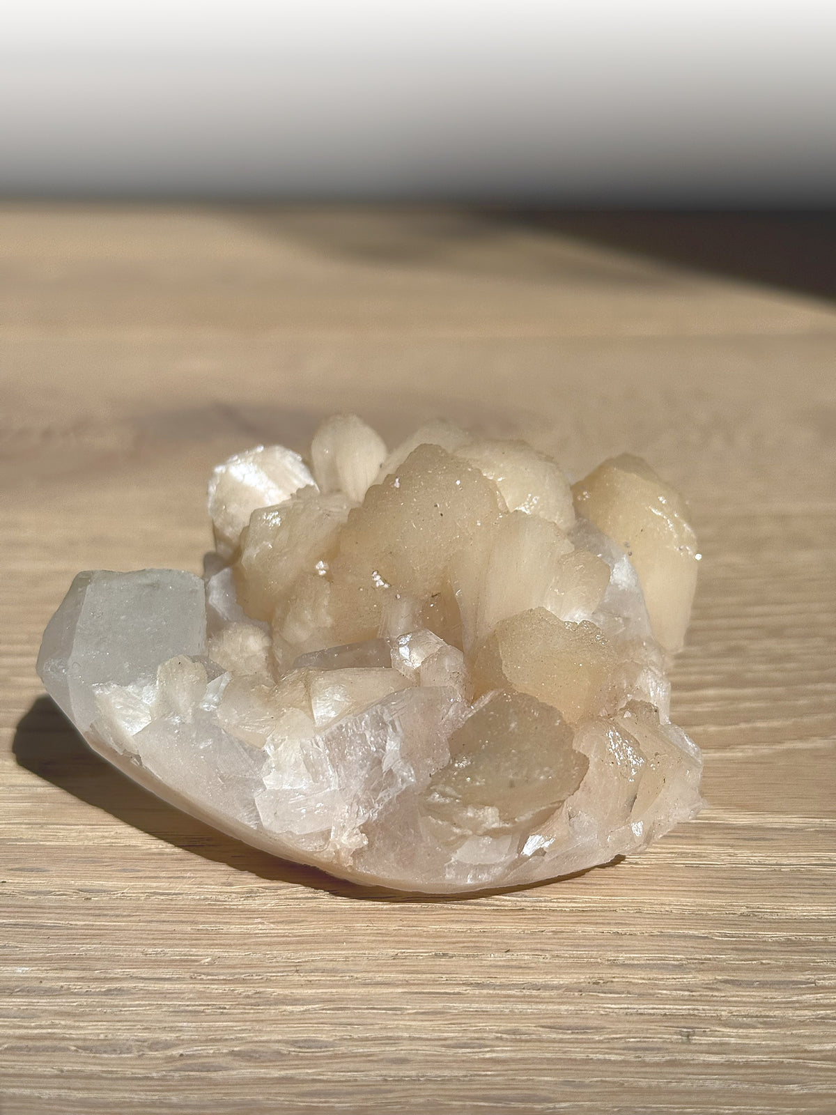 Peach stilbite and apophyllite cluster in warm sunlight