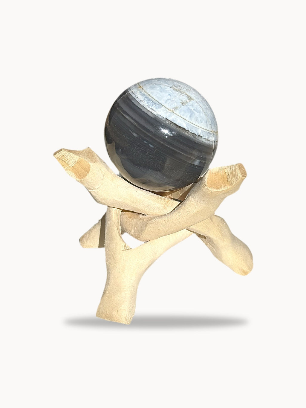 Medium blue opal sphere with charcoal bands on a wooden stand