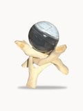 Medium blue opal sphere with charcoal bands on a wooden stand