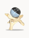 Small blue opal sphere, sky blue and black, on a wooden stand
