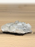 Clear apophyllite cluster on a wooden floor