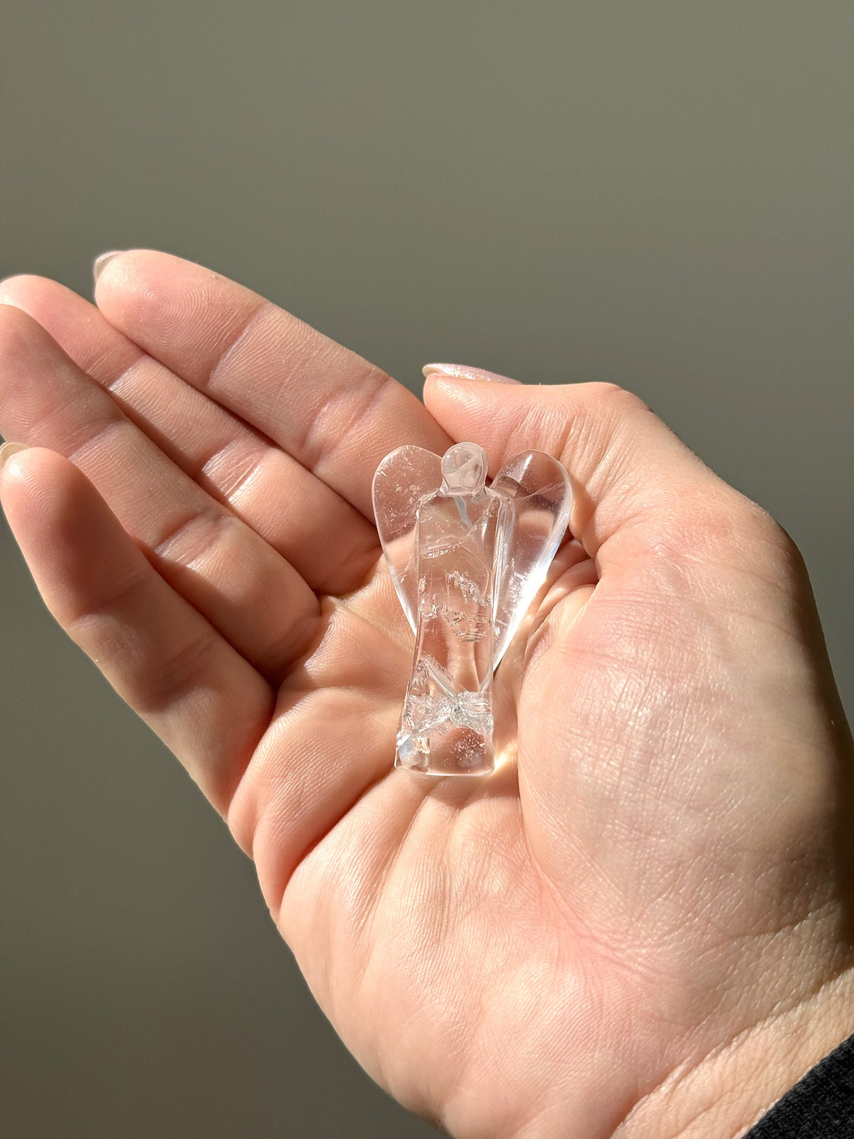 Small clear quartz angel resting in the palm