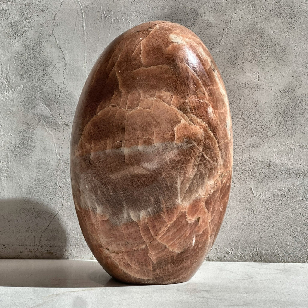 Polished dome of peach moonstone from Madagascar