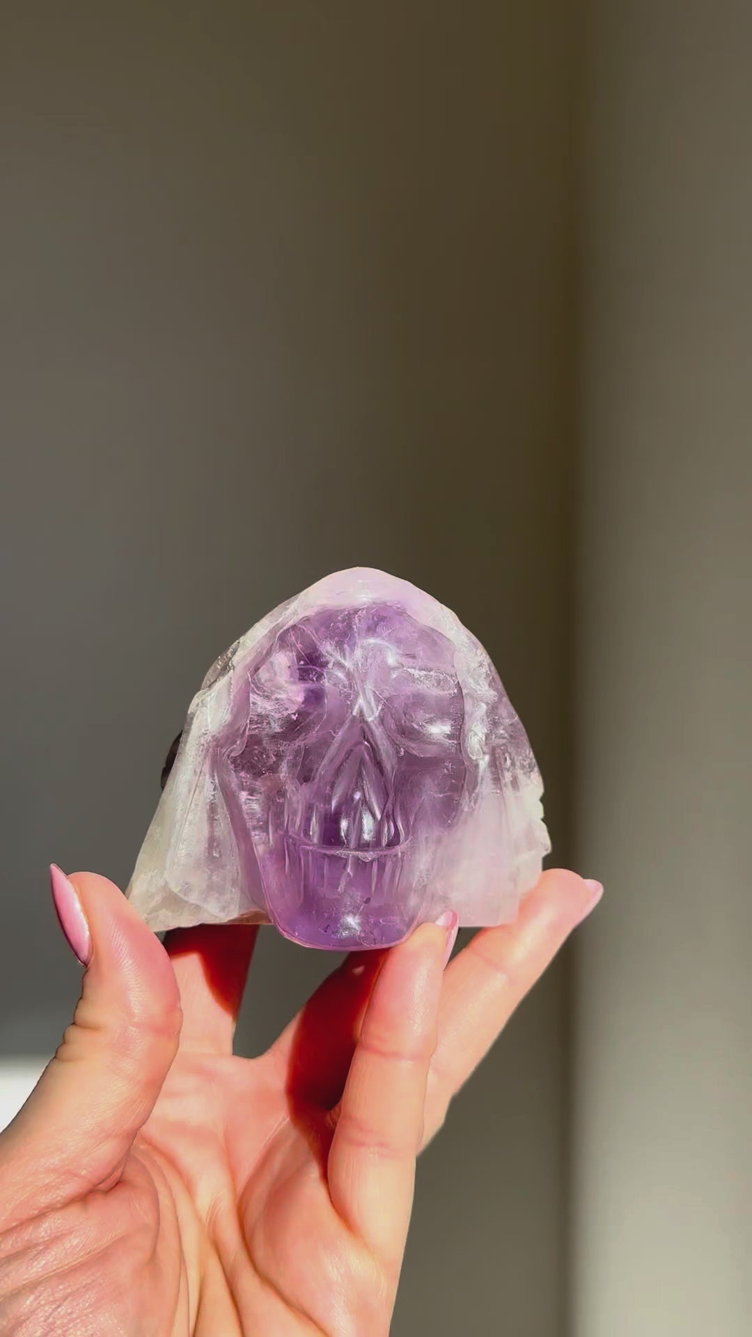 Amethyst skull turning in the sunlight in a hand
