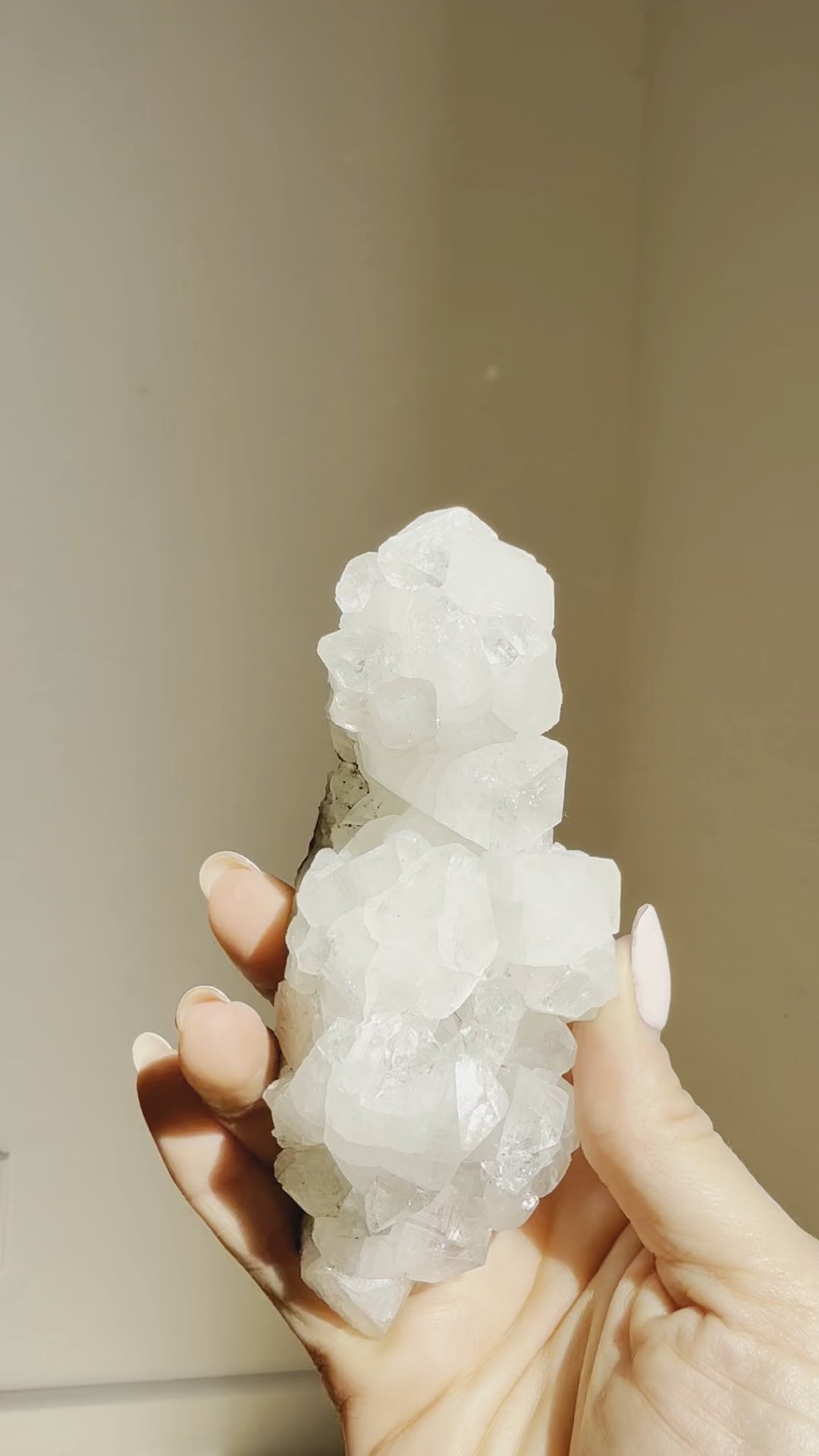 The sculptural apophyllite cluster held upright to show its tall point