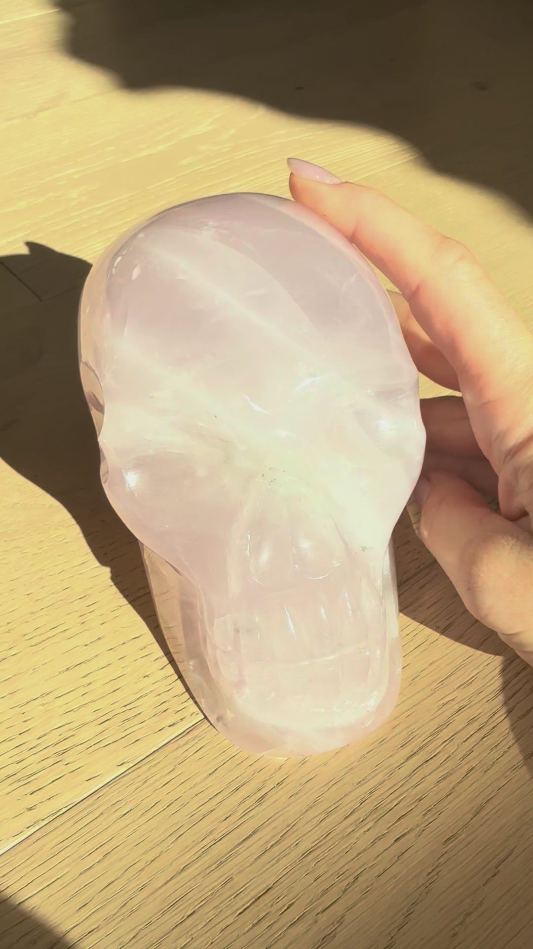 Large rose quartz skull turning in the sunlight