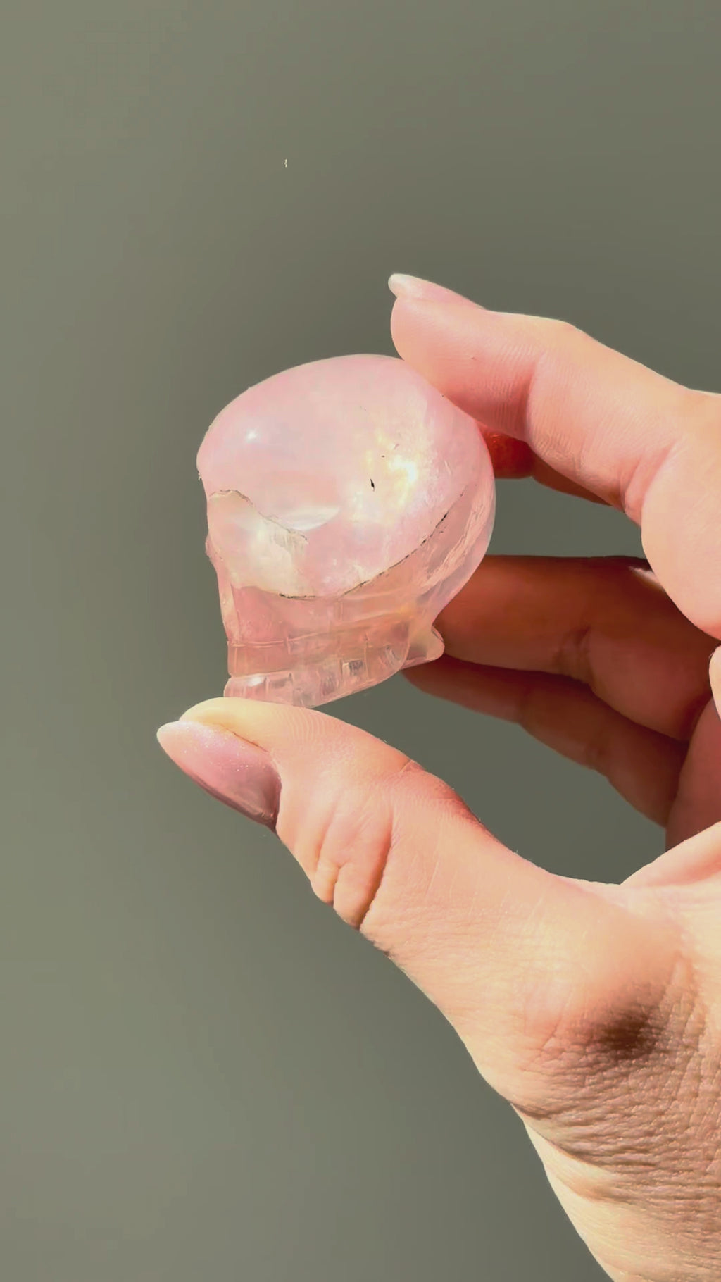 Small rose quartz skull turning in the sunlight