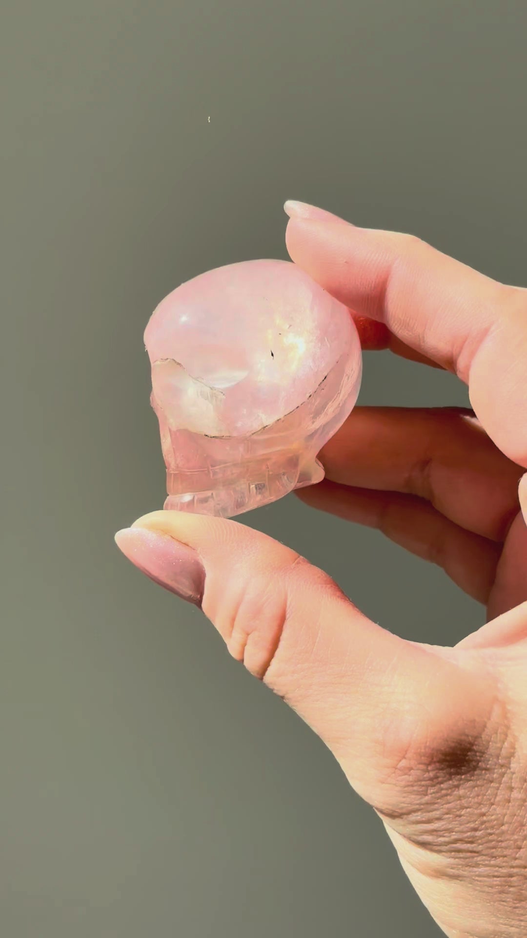 Small rose quartz skull turning in the sunlight