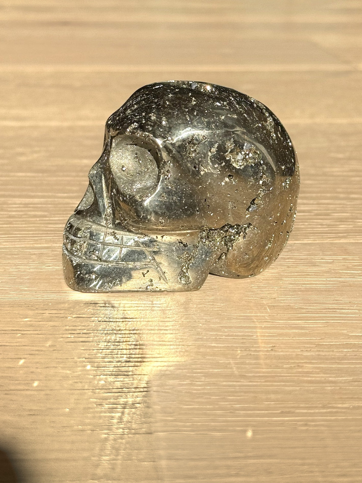 Pyrite skull No. 5, side view on a light oak floor