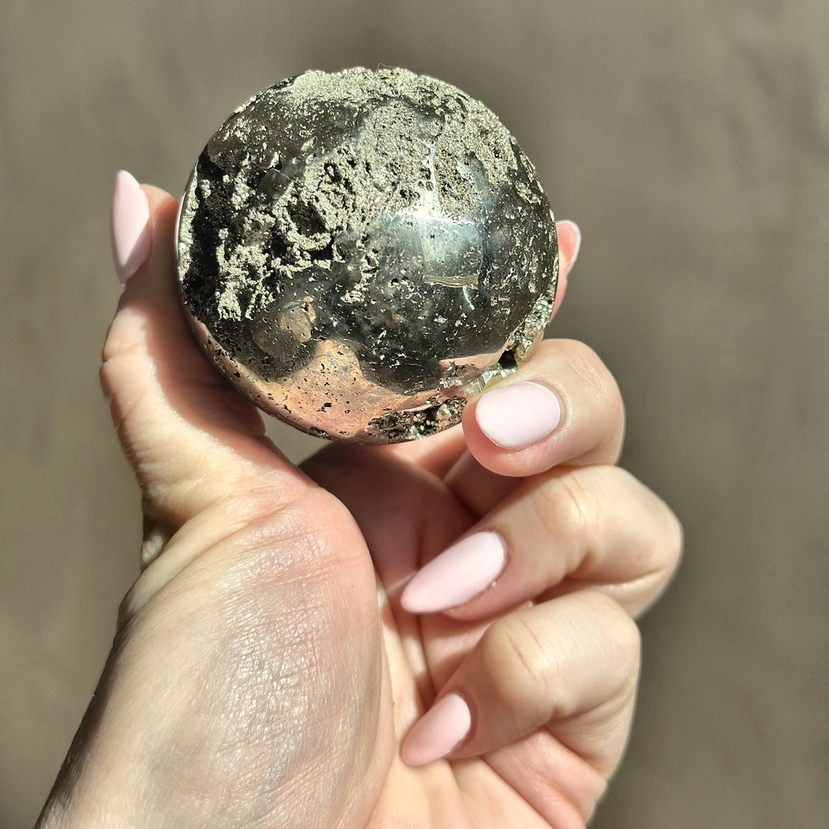 Polished sphere of golden pyrite