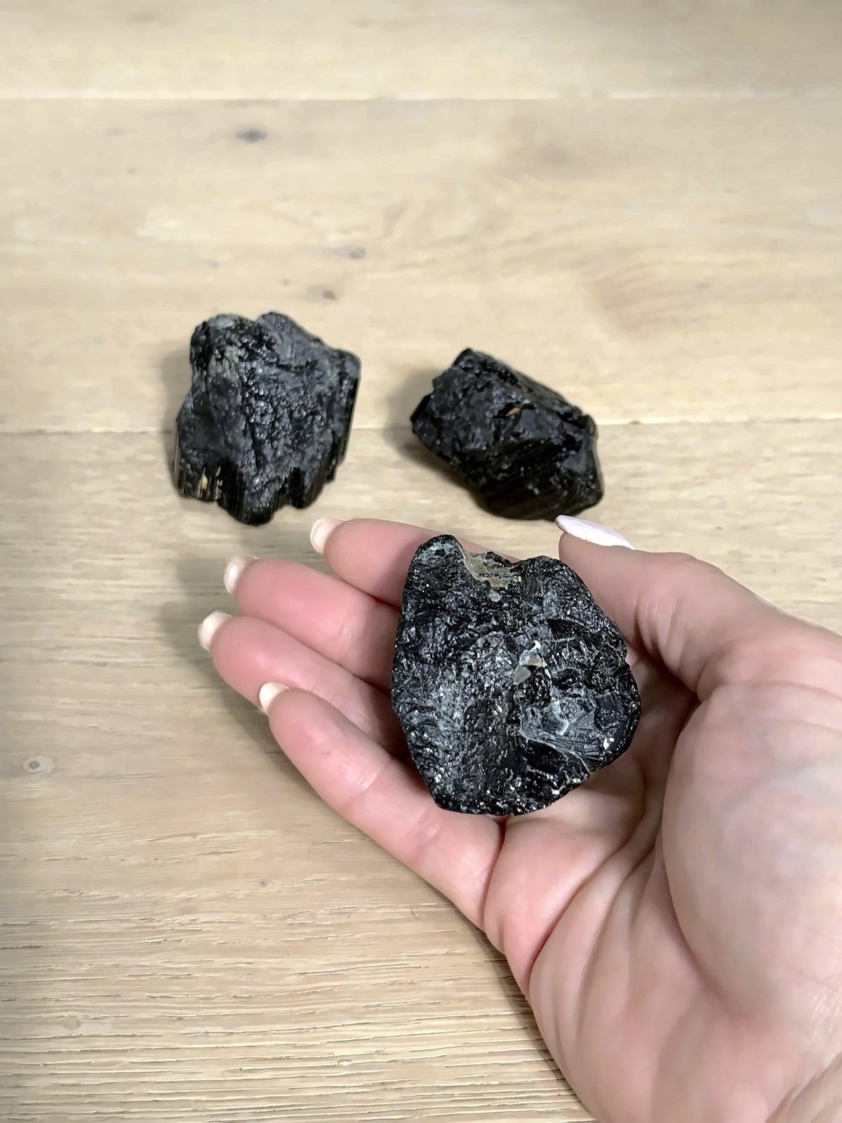 Raw black tourmaline in hand