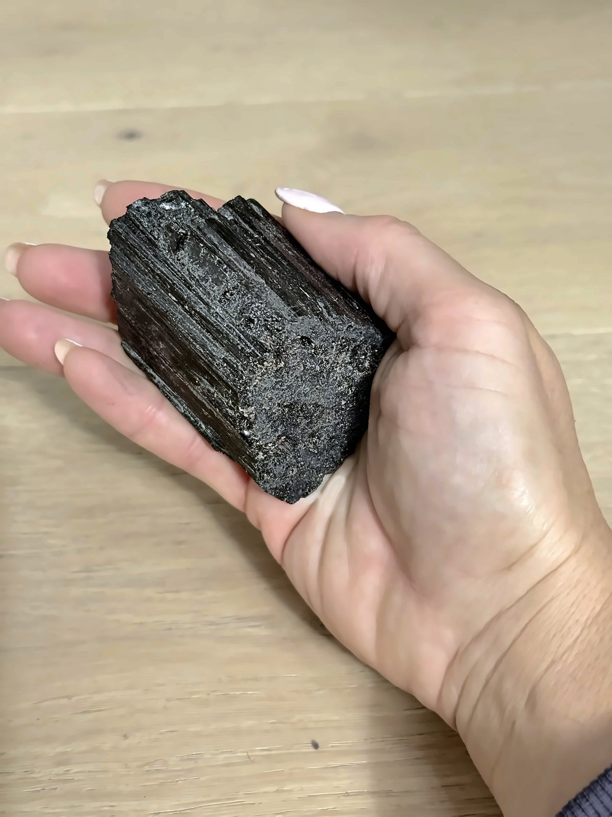 Raw black tourmaline held in hand