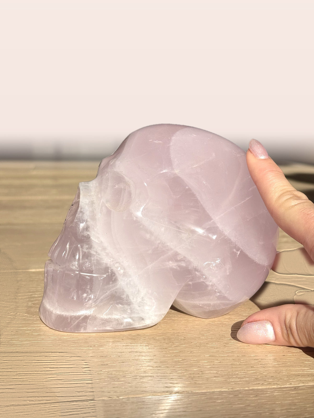 Large rose quartz skull, other side, with a hand for scale